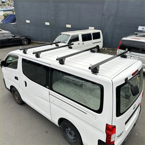 Black heavy duty roof rack 4 piece set mounted on white nissan nv350 caravan 2012-current backside view