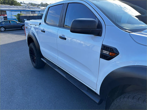 White ford ranger pickup with black stainless steel 4 inch oval tube running board and rugged tires side view