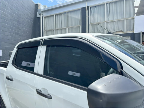 Black plastic window visors installed on white isuzu d-max 2021-2023 for weather protection and style