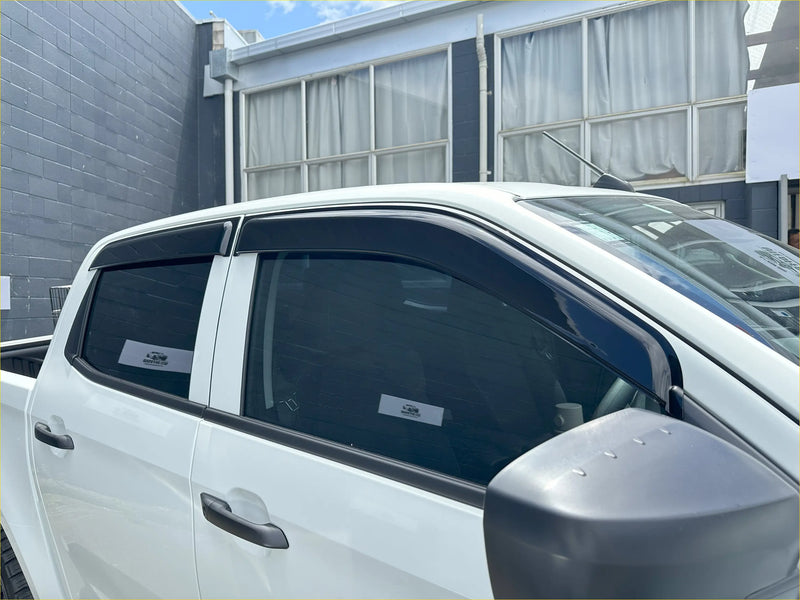 Black plastic window visors installed on white isuzu d-max 2021-2023 for weather protection and style