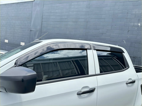 Black plastic window visors installed on a white isuzu d-max 2021-2023 for weather protection