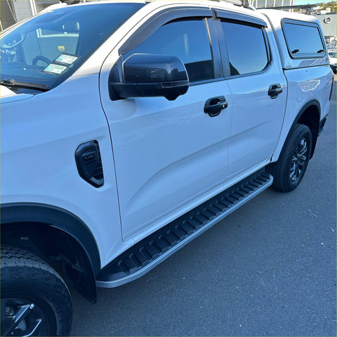 Silver metallic side step running board with textured ribbed surface and black rubber caps on white ford ranger 2022+ double cab