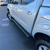 Black textured side step running board along lower edge of silver nissan navara 2015-current double door