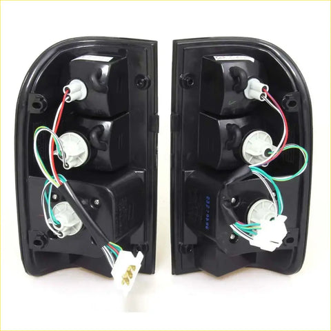 Backside of black plastic smoke led tail light assemblies with wiring for toyota hilux mk4 mk5 1997-2005 x2