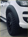 Black off-road tire with deep treads mounted on a black multi-spoke alloy wheel for smooth flares colorado 2017 2021