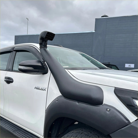 Black rubber snorkel mounted on white isuzu hilux pickup truck shown from the back side for toyota hilux 2015-2025