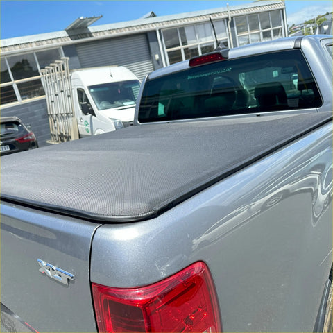 Gray textured soft tonneau cover fitted over the bed back side of a silver ford ranger px1 px2 px3 double cab pickup truck