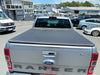 Silver ford ranger xlt pickup with a black soft tonneau cover shown from the back for isuzu d-max double cab use