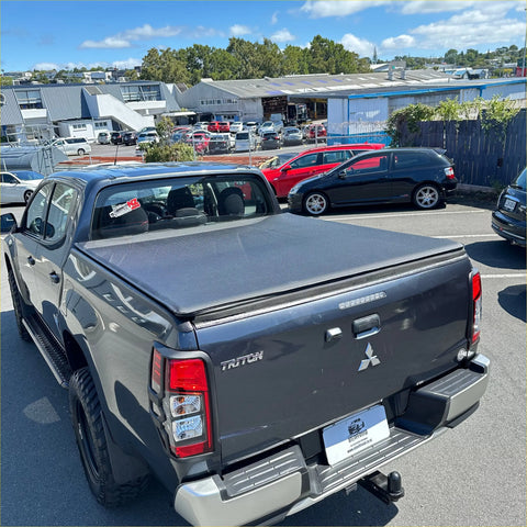 Black mitsubishi triton double cab with a textured soft tonneau cover for 2015-2023 models shown from the back side