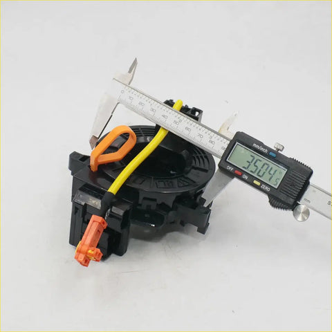 Black plastic steering wheel airbag tensioner with orange connectors and yellow wire for toyota hilux clock spring
