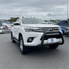 White toyota hilux pickup truck with matte black stainless steel nudge bar and black front bumper guard