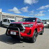 Vibrant red toyota hilux pickup with matte black stainless steel nudge bar and chrome accents front view