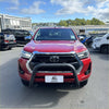 Red toyota hilux with a matte black stainless steel nudge bar and black front bumper guard from 2021 to 2025 models