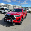 Vibrant red Toyota Hilux pickup with matte black stainless steel nudge bar and black front bumper guard chrome accents