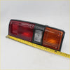 Black plastic tail light for Toyota Hilux 1978-1983 with red amber and clear lens sections shown from back side