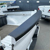Black textured rubber tailgate cover for white nissan navara 2021 pickup truck bed liner shown from back side