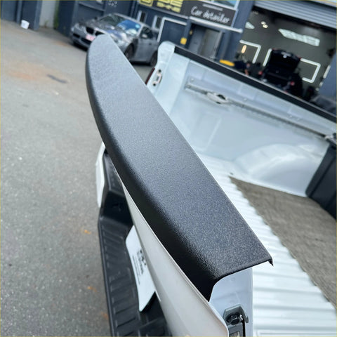 Black textured tailgate handle cover on the back of a white nissan navara 2021 pickup truck