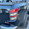 Back view of matte black taillight covers with red accents on glossy black mitsubishi triton 2015-2018 pickup truck