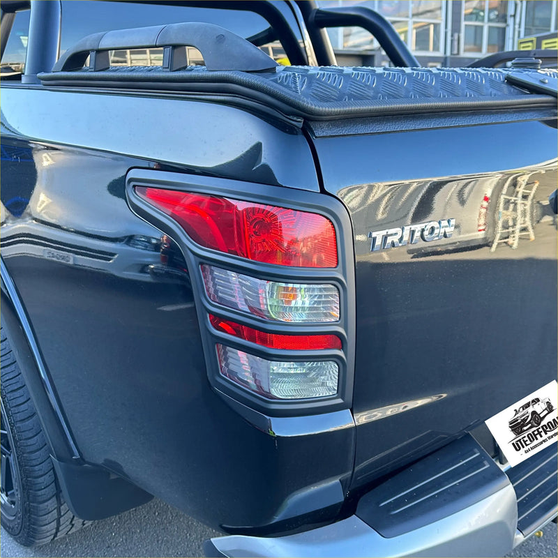 Black mitsubishi triton 2015-2018 with matte black taillight covers shown from the back with chrome accents
