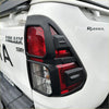 Black plastic taillight cover with red and clear lenses for white toyota hilux 2015-2020 sr back side view